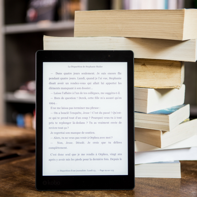 Tablet e livros.png tablet encostado em uma pilha de livros